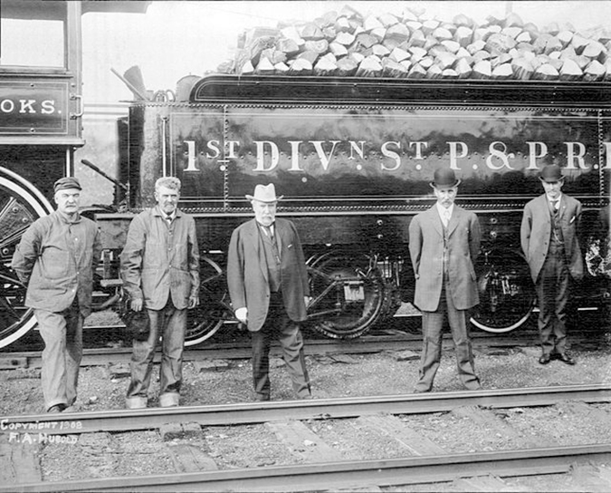 Hill (center) in front of his first locomotive, the W.M. Crooks.