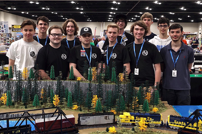 The EmpireLUG team collectively built the layout for the Brickworld Chicago convention. Front row (left to right): Lee Roberts, Anthony Davis, Ben Fillinger, Matt Welch, Gage Hunt, Andrès Cazenave-Tapie Back row (left to right): Josh Bretz, Max Finnemore, Gavin Smith, Quinlan Barwick, Nolan T.