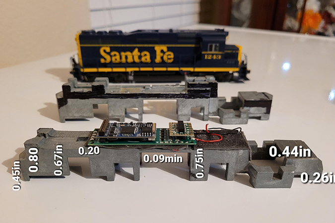 Thomas places sound chips and control cards in the belly of his locomotives.