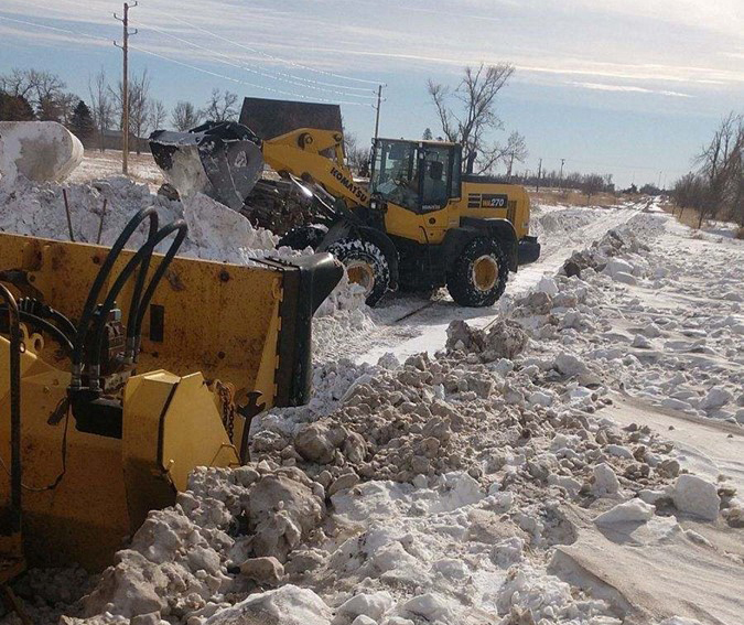 Warmer days require moving the snow, sometimes amid mud buildup.