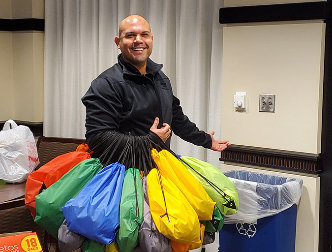 Fernando Garcia, a member of the NOC Diversity Council, gathers bags employees collected for Homeless Outreach in downtown Fort Worth.