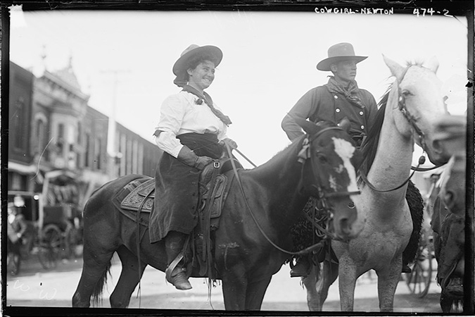 Cowgirl riding through Newton in 1908