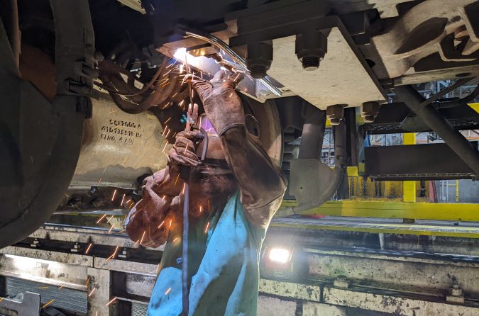 A machinist at our Topeka shop attaches the prototype ODIN to a locomotive for testing. 