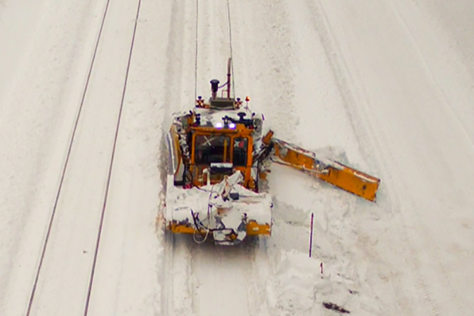 A Mini Dozer sweeping lighter snow off the tracks near Essex, Montana.