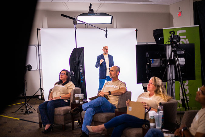 John Lovenburg, vice president, Environmental, speaks to Trackathon competitors watching remotely. In foreground are judges Kalisha Holland, chief diversity & inclusion officer; David Smat, general director Environmental Operations & Engineering, and Christy Thomas, assistant vice president, Technology Services.